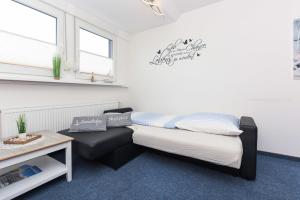 ein kleines Zimmer mit einem Bett und einem Sofa in der Unterkunft Ferienwohnung Haus Boje "Knurrhahn" in Neuharlingersiel