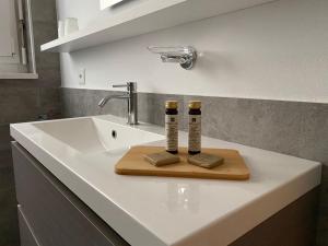 a bathroom sink with two bottles on a wooden cutting board at APNC Apartment Castagnola in Lugano