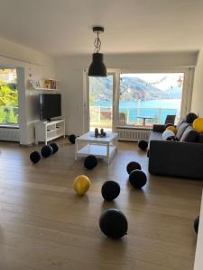 een woonkamer met zwarte en gele bollen op de vloer bij APNC Apartment Castagnola in Lugano