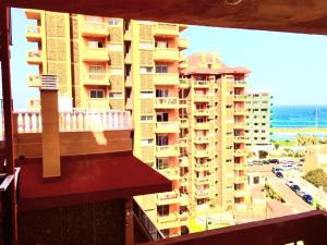 Elle offre une vue sur un grand bâtiment depuis son balcon. dans l'établissement Regina Pacis (VALLE-LUZ), à Puerto de la Cruz