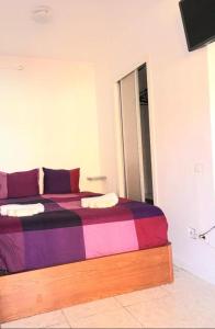 a bedroom with a bed with a colorful blanket at Regina Pacis (VALLE-LUZ) in Puerto de la Cruz