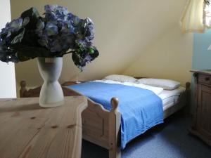 プレローにあるFeWo Abendsonneのベッドルーム1室(ベッド1台付)、紫の花の花瓶1枚