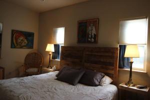 ein Schlafzimmer mit einem Bett mit zwei Lampen und zwei Fenstern in der Unterkunft Upper Ranch - 100 Acre Mountain Views in Whitehall