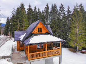 Cabaña de madera con nieve en el techo en Brvnara Vukovine en Nova Varoš