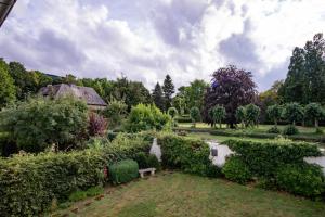 a garden with a pond and a bench and trees at Altstadt Apartment in Goslar