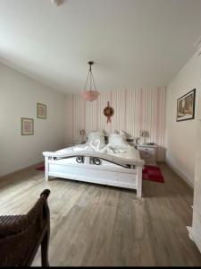 a white bedroom with a large white bed in it at Mainsommer in Kemmern