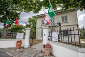 una casa con banderas delante de una valla en La Locanda di Adele - Il Giardinetto B&B, en Scarperia