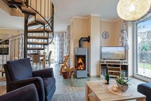 a living room with a fireplace and a staircase at Wellness - Ferienhaus Steilküste in Klausdorf