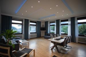 a living room with a table and chairs and windows at Ferienwohnung Höpperger in Schönberg im Stubaital