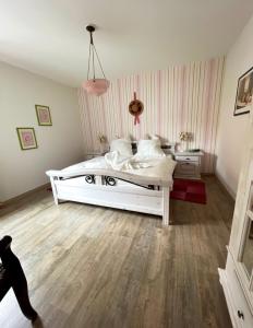 1 dormitorio con cama blanca y suelo de madera en Mainsommer en Kemmern