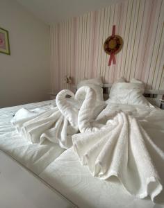 a white bed with two swans laying on it at Mainsommer in Kemmern