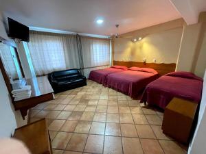 una camera d'albergo con due letti e una televisione di HOTEL BUGAMBILIAS a Città di Oaxaca