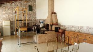 a kitchen with a stove and a refrigerator at Pousada Mendonça in Jaboticatubas