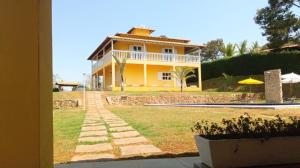 雅博蒂卡圖巴斯的住宿－Pousada Mendonça，黄色房子前面有一条路