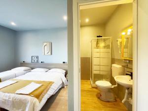 ein Schlafzimmer mit 2 Betten und ein Badezimmer mit einem Waschbecken in der Unterkunft Il Giramondo in Mailand