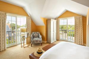 a bedroom with a bed and large windows at The Grand Hotel in Kennebunk