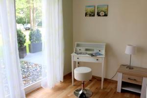 einen Schreibtisch mit einem Stuhl neben einem Fenster in der Unterkunft Lachmöwe App 35 in Dierhagen
