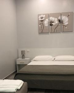a bedroom with two paintings of flowers on the wall at B&B Vittorio Emanuele in Cirò Marina