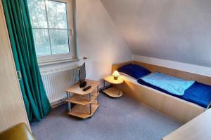 a small bedroom with a bed and a desk with a computer at Am Deich 18 in Zingst