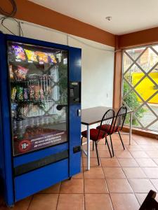 uma máquina de venda automática numa sala com uma mesa e cadeiras em HOTEL BUGAMBILIAS em Oaxaca de Juárez