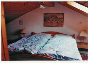 ein großes Bett in einem Schlafzimmer mit Dachgeschoss in der Unterkunft Ferienhaus Waldschrat - Komplettpreis in Zandt