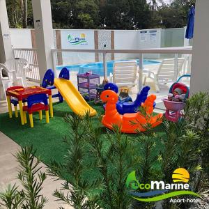 uma área recreativa para crianças com brinquedos e uma piscina em Ecomarine Apart-hotel 800 m Beto Carrero em Penha