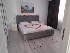 un dormitorio con una cama con un corazón dibujado en ella en Casa Sannicolau en Sînnicolau Mare