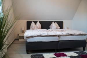 um quarto com uma cama com almofadas cor-de-rosa em Ferienhaus Uckerseeblick em Prenzlau