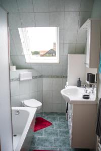 uma casa de banho com um lavatório, um WC e uma janela. em Ferienhaus Uckerseeblick em Prenzlau
