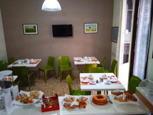 a room with tables and chairs with food on them at Il Quadrifoglio Room& Suite in Palermo