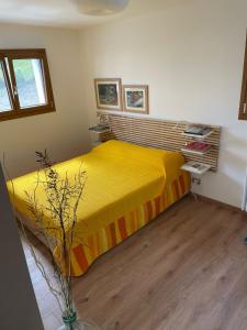 a bedroom with a yellow bed in a room at Baita Mael in Armeno