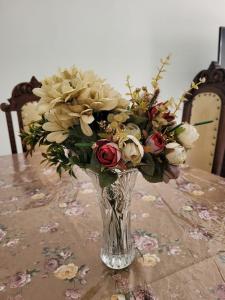 a vase filled with flowers on a table at Sobrado 4 amplo e confortável em condomínio in Corumbá