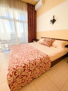 1 dormitorio con cama y ventana grande en Nash Parus Apartments, en Kacha