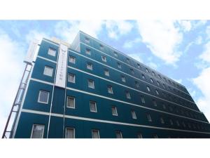 仙台的住宿－Sendai Business Hotel Ekimae - Vacation STAY 71934v，一座高大的蓝色建筑,背后是天空