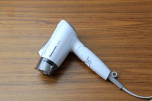 a white electric hair dryer on a wooden table at Sendai Business Hotel Ekimae - Vacation STAY 71912v in Sendai