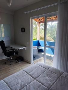 a bedroom with a bed and a desk and a chair at Pousada Vila dos Sonhos in Ituporanga
