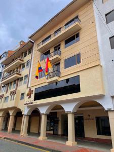 un edificio con dos banderas a un lado en Hotel Patrimonio, en Cuenca