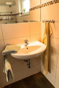 La salle de bains est pourvue d'un lavabo blanc et d'un miroir. dans l'établissement K2 Bungalow - Strandhaus Königsberger Allee 8 - FERIENDOMIZIL HOLLICH, à Grömitz