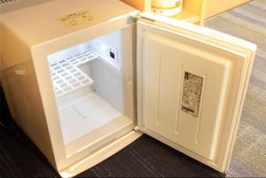 - un petit réfrigérateur blanc avec une porte ouverte dans l'établissement Sendai Business Hotel Ekimae - Vacation STAY 71907v, à Sendai