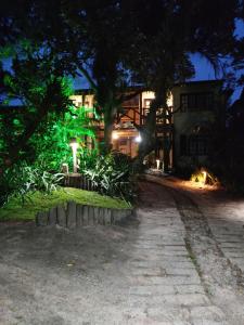 a house lit up at night with lights at Nalua Guest House in Guarda do Embaú