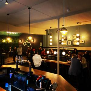 um restaurante com um bar com pessoas sentadas à sua volta em The Waterman's Arms em Londres