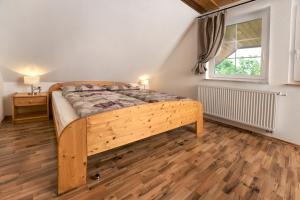 1 dormitorio con cama de madera y ventana en Ferienhof Wuchner - Fewo "Wintertraum", en Fröhnd