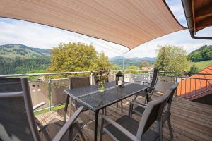 een tafel en stoelen op een balkon met uitzicht bij Ferienhof Wuchner - Fewo "Wintertraum" in Fröhnd