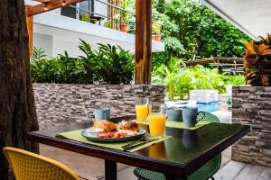 una mesa con un plato de comida y zumo de naranja en Hotel Elixir en Tamarindo