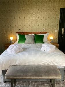 a bedroom with a large bed with green and white pillows at The Waterman's Arms in London