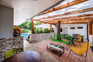 un patio con mesa y sillas en una terraza en Hotel Elixir en Tamarindo
