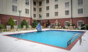 ein großer Pool in einem Hotel mit Tischen und Stühlen in der Unterkunft Holiday Inn Express & Suites - Tuscaloosa-University, an IHG Hotel in Tuscaloosa