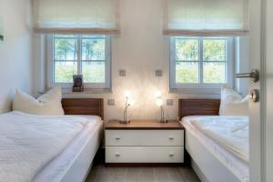 duas camas num quarto com duas janelas em Deichgraf Strandresidenz 1 Ahrenshoop em Zingst