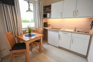 a kitchen with a table and a sink and a table and chairs at Zur schönen Aussicht - FW 4 in Dahme