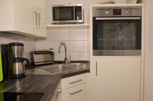 a kitchen with a sink and a microwave at Fewo im Haus des Kurgastes in Heiligenhafen